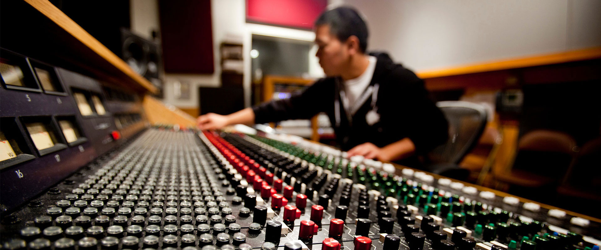 A student using a sound board with many knobs and dials
