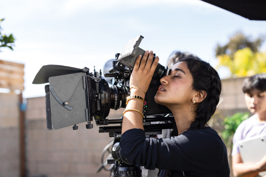 LMU SFTV Student looks into film camera on set